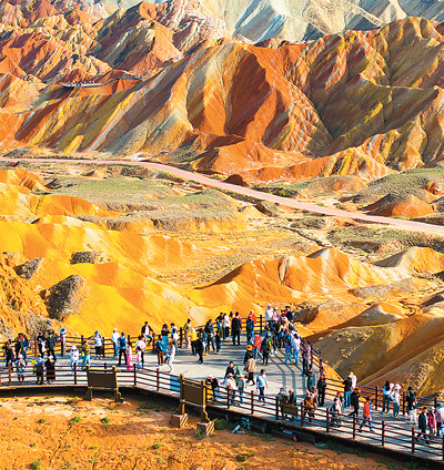秋以來，甘肅省張掖七彩丹霞景區迎來大量游客，景區持續強化服務管理措施，應對旅游高峰。圖為今年國慶假期期間，游客在張掖七彩丹霞景區游覽觀光。   楊 瀟攝（人民視覺）