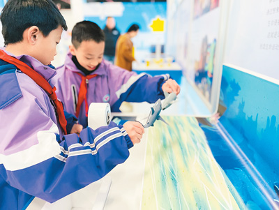 在位于廣西河池羅城仫佬族自治縣的羅城科技館內，學生在體驗模擬定格動畫的科普展品。