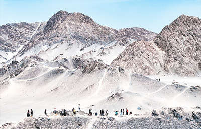 青海茫崖荒漠戈壁上的黑獨山神秘而獨特，引得全國各地游客前來打卡。王章華攝（人民圖片）