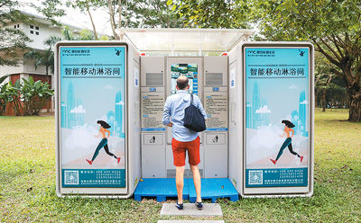 2024年12月27日，一名外國游客在深圳蓮花山公園里了解智能移動淋浴間。