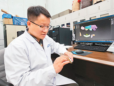 中國社會科學院科技考古與文化遺產保護重點實驗室助理研究員劉勇在介紹對內蒙古赤峰市松山區彩陶坡遺址出土蚌飾開展的實驗室考古。   本報記者 趙曉霞攝