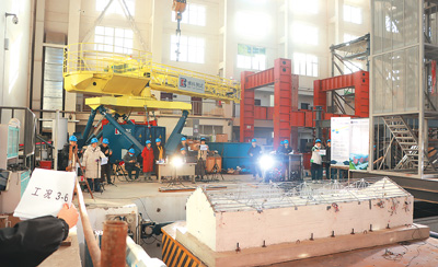 聯合科研團隊密切關注振動臺上民居模型的抗震性能。本報記者 康 樸攝