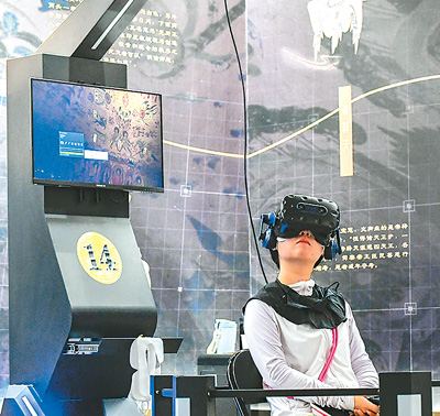 在“尋境敦煌——數字敦煌沉浸展”，游客借助VR設備沉浸式游覽莫高窟第285窟虛擬場景。   新華社記者 郎兵兵攝