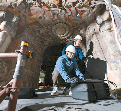 云岡研究院數字化保護中心工作人員在云岡石窟第10窟進行數據采集。   新華社記者 詹 彥攝