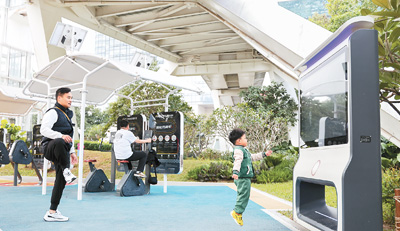 2024年12月27日，在廣東省深圳市筆架山公園里，小朋友和家長一起使用智能互動屏鍛煉身體。新華社記者 梁 旭攝