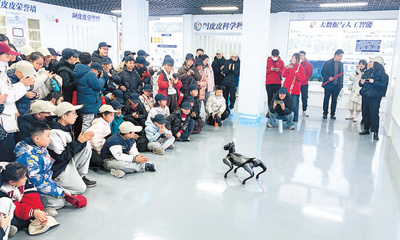 參加研學游的學生在濟寧“阿皮皮科學世界”腦科學與人工智能科普基地，與機器人互動。   華中領攝