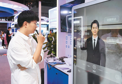 2024年7月，工作人員在2024全球數字經濟大會數字經濟沉浸式體驗區與數字人交流。   新華社記者 任 超攝