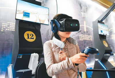   游客借助VR眼鏡等智能設備，在“尋境敦煌”虛擬場景中體驗擂鼓。   新華社記者 郎兵兵攝