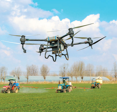  3月16日，山東青島萊西市沽河街道，植保無人機、長臂噴霧機在田間對小麥進行管護。張進剛攝（人民視覺）
