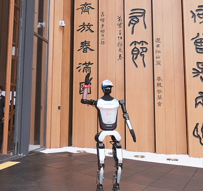  在日本大阪世博會，人形機器人在中國館外向嘉賓招手致意。   新華社記者 賈浩成攝