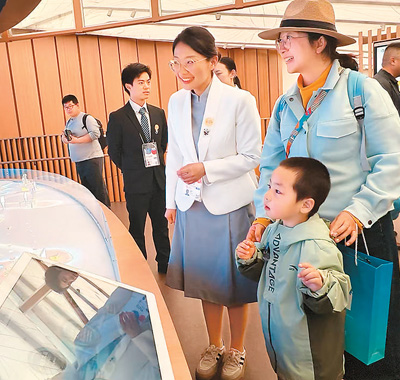 在日本大阪世博會中國館二樓“生生不息”展區，工作人員（左三）向參觀者介紹中國的智慧城市方案。   本報記者 楊俊峰攝