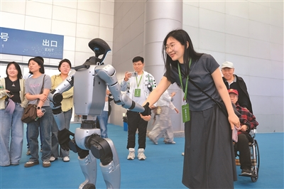 近日舉行的第三屆中國（安徽）科技創新成果轉化交易會上，現場展示的人形機器人與觀眾握手。楊 潔攝（人民視覺）