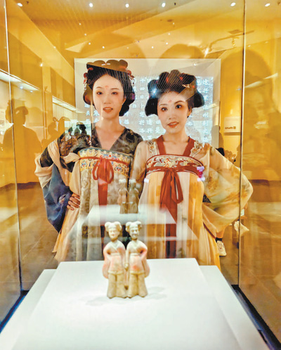 游客與北魏彩繪陶牽手女俑合影。 楊焱斐攝