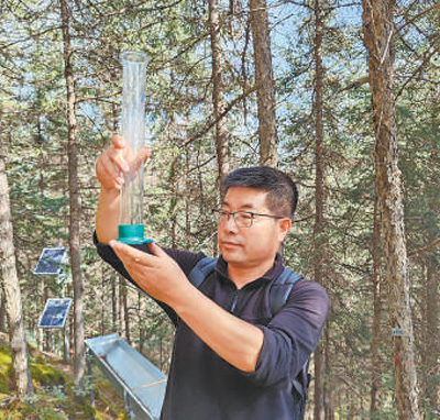 敬文茂在觀測降水情況。 本報記者 宋朝軍攝