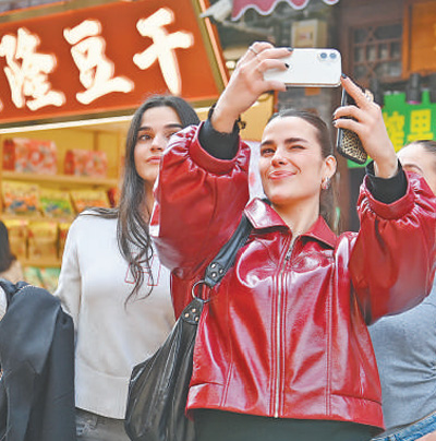 重慶市沙坪壩區磁器口古鎮，外國游客正在拍照打卡。 孫凱芳攝（影像中國）