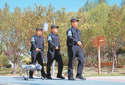 5月9日，在甘肅省金昌市金川區龍首湖公園，一只警用機器狗和民警一起開展例行巡邏。 張宏斌攝（人民圖片）