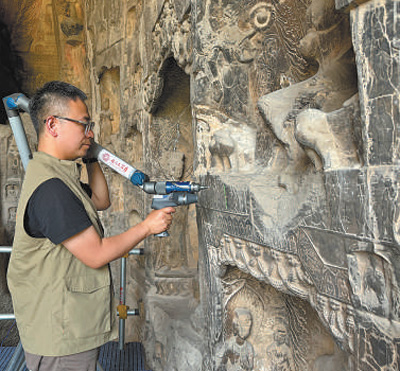 龍門石窟研究院的工作人員對石窟造像進行數字化掃描。   本報記者??張文豪攝