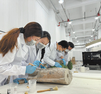 龍門石窟研究院的工作人員在修復石窟文物。??   本報記者??張文豪攝