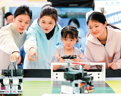 4月28日，在福建省福州市鼓樓區鼓東街道冶山春秋園，小朋友正在體驗足球機器人。   謝貴明攝（人民視覺）