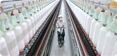 2025年4月15日，山東正凱新材料股份有限公司的工人在智能化生產線上加工高端紗線。   孫中喆攝（人民圖片）