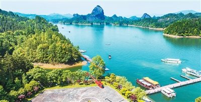 江西省宜春市銅鼓縣天柱峰景區依托秀美山水，打造機器人互動體驗、水上卡丁船競賽、直升機高空游覽等新業態，讓游客感受山水與科技的融合之趣。 周 亮攝（人民圖片）