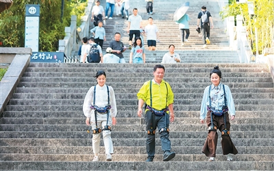 福建省福清市石竹山景區，游客穿戴“外骨骼機器人”下山。 謝貴明攝（人民圖片）