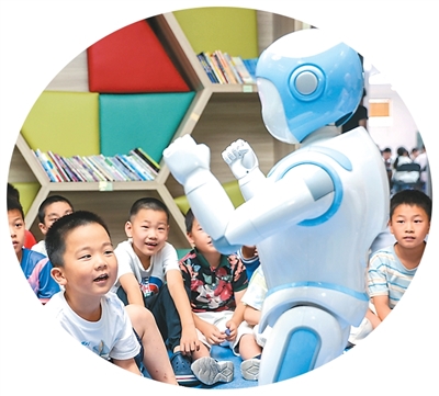 7月9日，浙江省湖州市德清縣阜溪街道社區教育中心愛心托管班，小朋友與機器人互動。   姚海翔攝 （人民圖片）