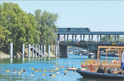近期，法國巴黎遭遇嚴重熱浪。巴黎塞納河最近開放3處公共游泳區域，供市民和游客度過炎炎夏日。圖為日前，人們在塞納河消暑休閑。   本報記者? 尚凱元攝