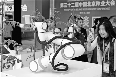 圖為觀眾在展區觀看中國科學院遺傳與發育生物學研究所科研團隊研發的世界首臺可自動巡航雜交授粉育種機器人。本報記者 洪星攝