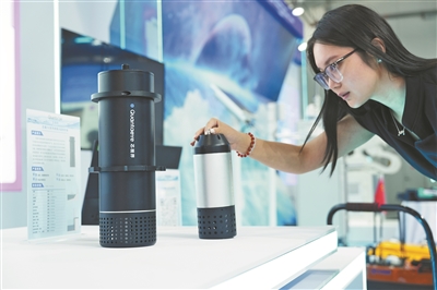 參觀者在看“水環境偵察兵”的地表水及排水管網監測終端。本報記者 洪星攝