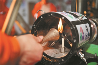 在科考船甲板面，工作人員從搭載在“海馬”號深海遙控潛水器上的采火裝置里取火（9月18日攝）。新華社記者 盧漢欣攝