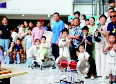 參觀者在上?？破招慊顒由嫌^看特斯拉線圈的放電演示。新華社發