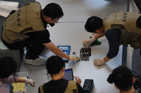 2024年5月20日，考古人員在武王墩墓考古發掘現場清理出土文物。新華社記者 張端攝