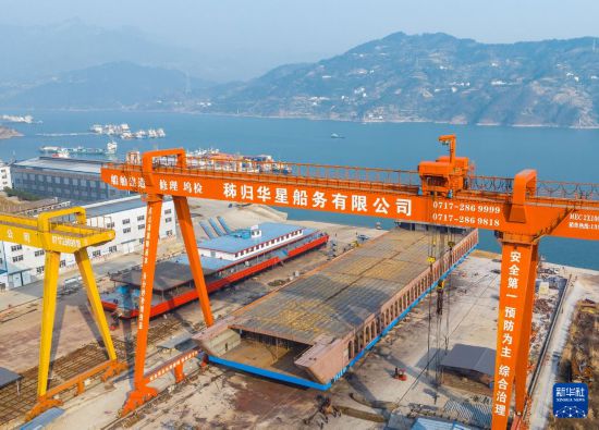 1月20日，秭歸縣華星船務有限公司建造的新能源滾裝船從制造平臺向江上移動（無人機照片）。新華社發（鄭家裕攝）