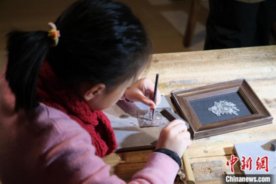 2月7日，浙江杭州，小朋友在體驗浙江永康錫雕技藝。春節期間，浙江省非物質文化遺產館成為家庭出游的熱門之選，民眾在傳統技藝體驗中感受年味。中新社記者 曹丹 攝