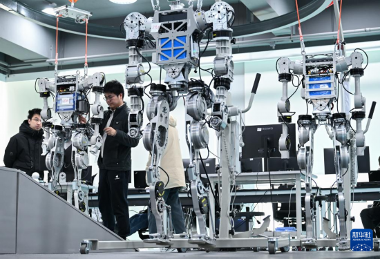2月24日，在武漢格藍若智能技術股份有限公司，研發團隊成員何琦（左二）在調試人形機器人。新華社記者 杜子璇 攝