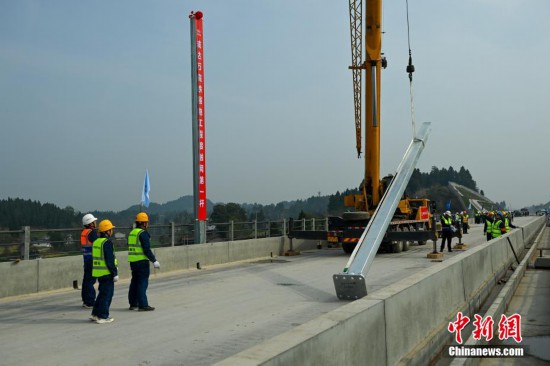2月28日，四川資陽，工人師傅吊裝第二根接觸網支柱。中新社記者 劉忠俊 攝