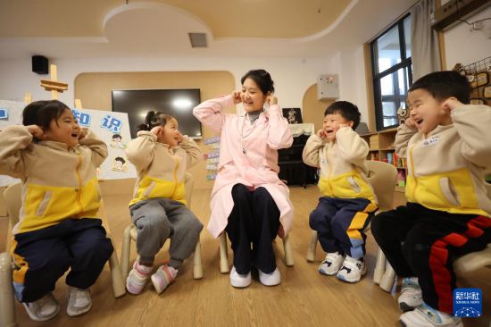 3月3日，在河南省開封市河南大學幼兒園金明園區教室里，保健老師與孩子互動做護耳游戲。新華社發（石斐攝）