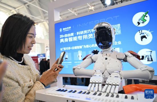 3月6日，在國家會展中心（天津），觀眾觀看一款安裝有靈巧手的機器人彈鋼琴。新華社記者 孫凡越 攝