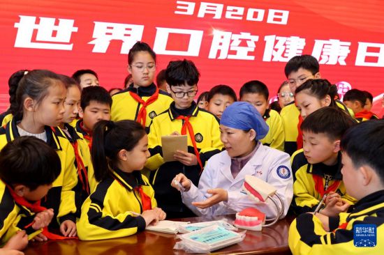 3月20日，醫務人員在山東省棗莊市市中區文化路小學與學生互動交流，傳授口腔健康知識。新華社發（孫中喆 攝）