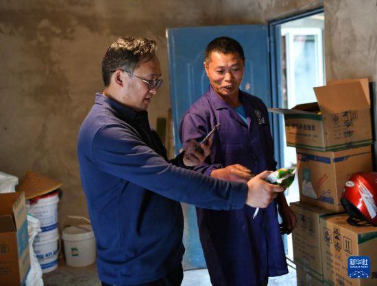   在四川省眉山市彭山區，譚周亮（左）在向當地一名水產養殖戶了解飼料投喂情況（2022年4月13日攝）。新華社記者 劉坤 攝