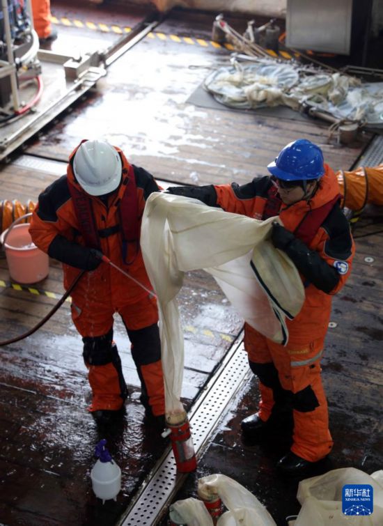 4月4日，科考隊員在“雪龍2”號上沖洗浮游生物垂直網以獲取樣本。新華社記者 黃韜銘 攝