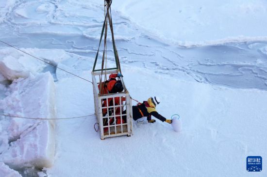 3月29日，科考隊員乘吊籠到冰面布放浪-冰浮標和海冰漂流浮標。新華社記者 黃韜銘 攝