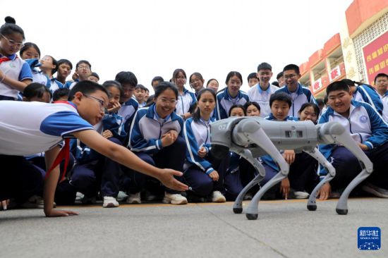 5月7日，在河南省濟源市軹城鎮校園科技節活動上，同學們與機器狗互動。新華社發（段二平攝）