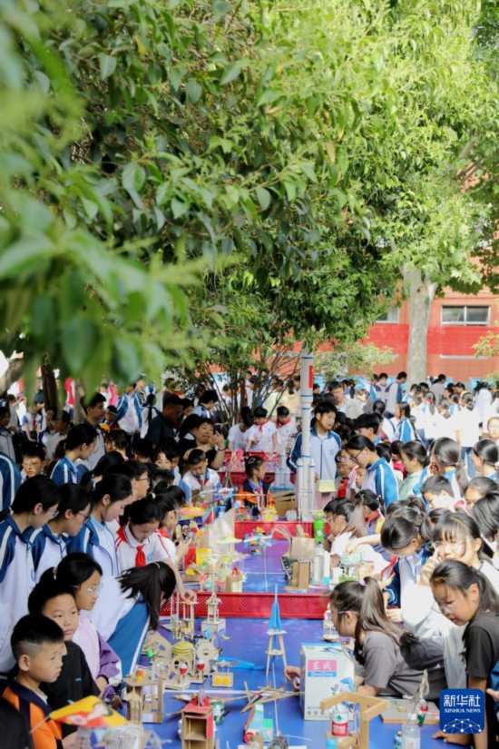 5月7日，在河南省濟源市軹城鎮校園科技節活動上，同學們在參觀科技小制作。新華社發（段二平攝）
