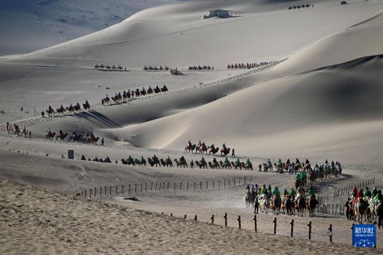 5月10日，游客乘騎駱駝在甘肅省敦煌市鳴沙山月牙泉景區游覽。新華社發（張曉亮 攝）