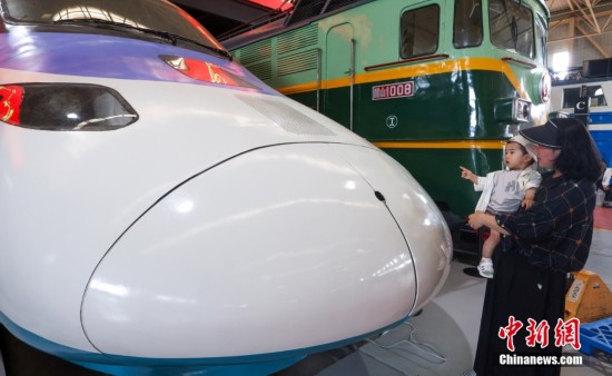 5月18日，家長帶著小朋友參觀“中華之星”電力機車車頭。中新社記者 賈天勇 攝