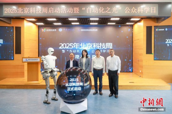 圖為人形機器人與嘉賓共同啟動北京科技周。中新社記者 賈天勇 攝