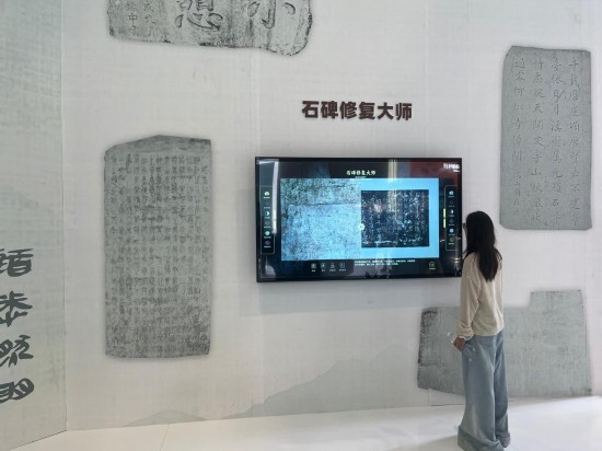 5月24日，在第二十一屆文博會上，觀眾體驗用數字技術修復石碑文字。新華社記者 陳宇軒 攝