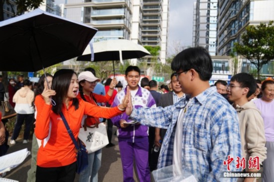 6月7日，云南昆明，老師與考生擊掌加油。中新社記者 劉冉陽 攝